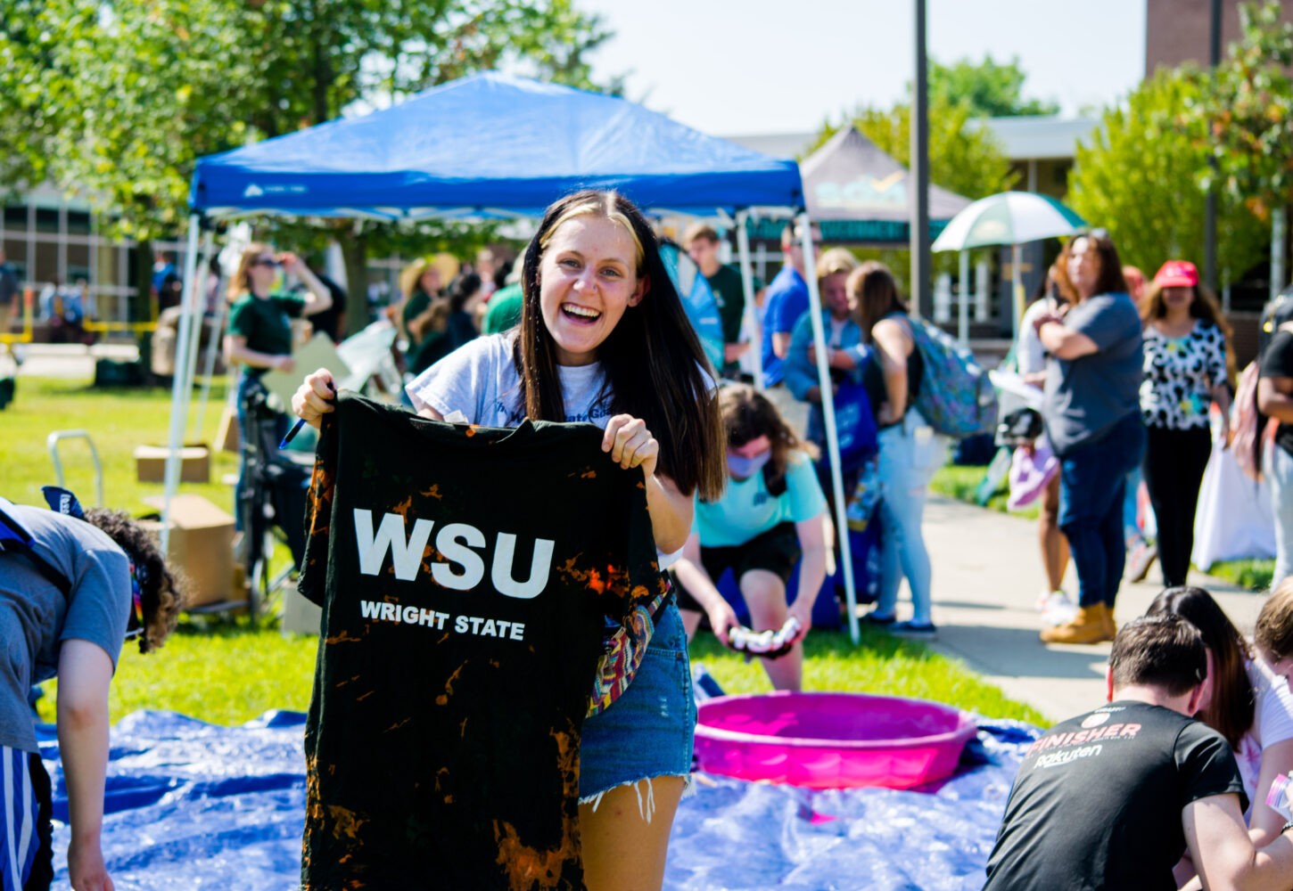 student holding up WSU t-shirt at fall festival